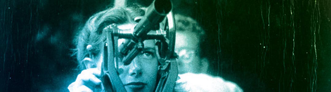 a woman looks through the scope of a surveyors transit circa 1945
